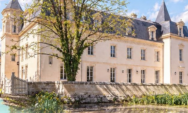 Le Château Sénéjac derrière son arbre et le muret du parc